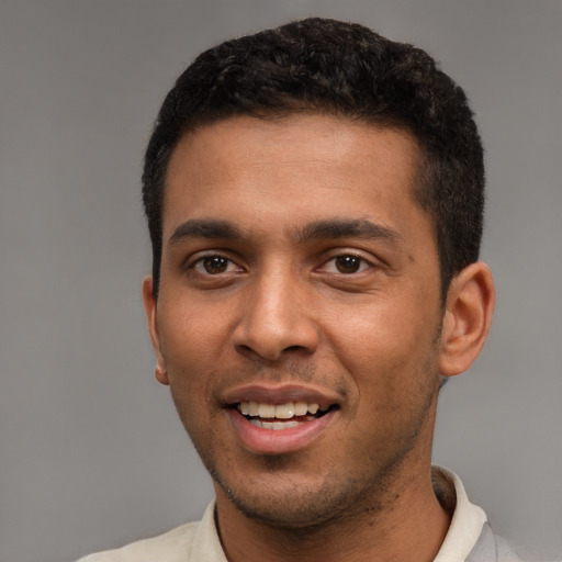 Joyful black young-adult male with short  black hair and brown eyes