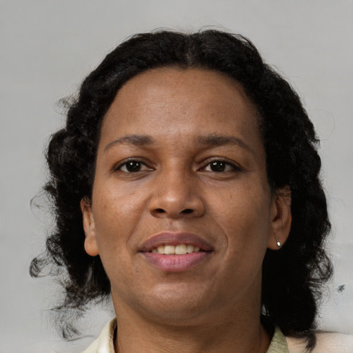 Joyful black adult female with medium  brown hair and brown eyes