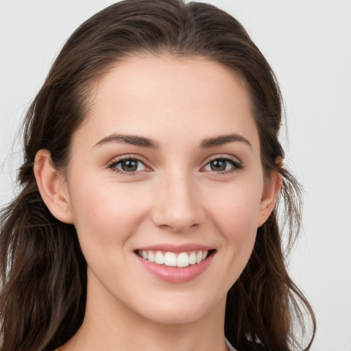 Joyful white young-adult female with long  brown hair and blue eyes