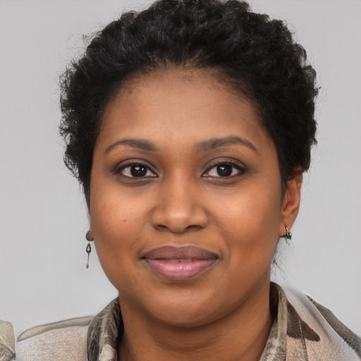 Joyful black young-adult female with short  brown hair and brown eyes