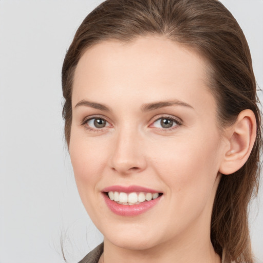 Joyful white young-adult female with medium  brown hair and grey eyes