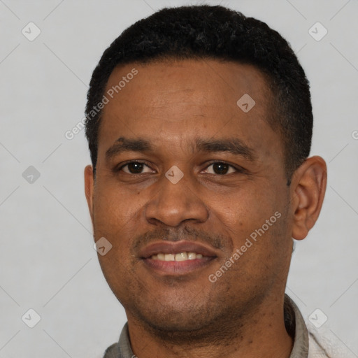 Joyful black young-adult male with short  black hair and brown eyes