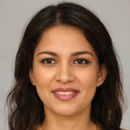 Joyful latino young-adult female with medium  brown hair and brown eyes