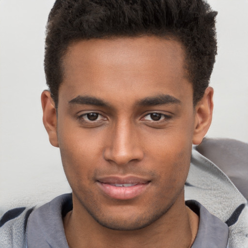 Joyful black young-adult male with short  brown hair and brown eyes