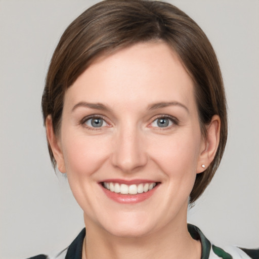 Joyful white young-adult female with medium  brown hair and grey eyes