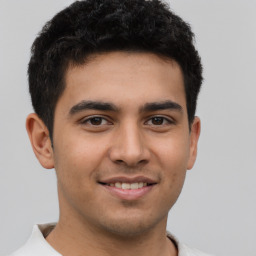 Joyful latino young-adult male with short  brown hair and brown eyes