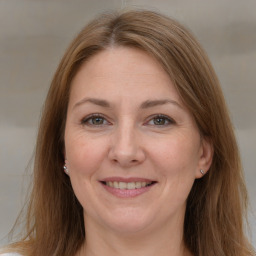 Joyful white adult female with long  brown hair and grey eyes