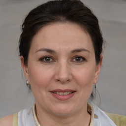 Joyful white adult female with medium  brown hair and brown eyes