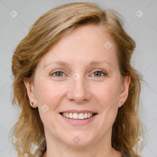 Joyful white adult female with medium  brown hair and blue eyes