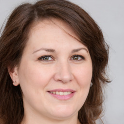 Joyful white adult female with long  brown hair and brown eyes