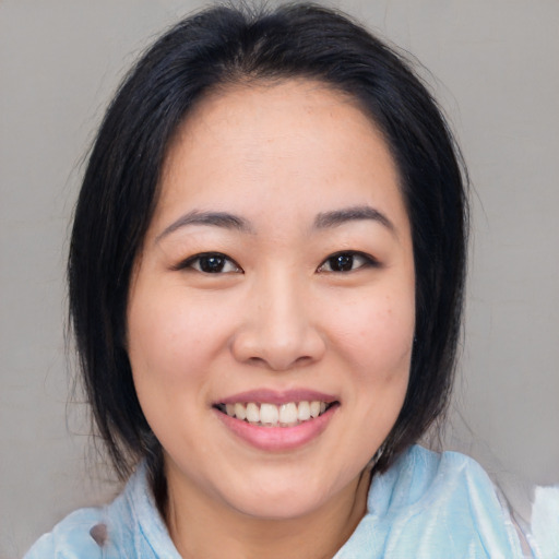 Joyful asian young-adult female with medium  black hair and brown eyes