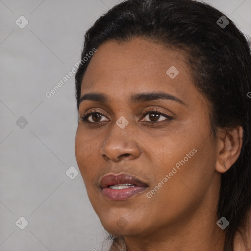 Joyful black young-adult female with long  black hair and brown eyes