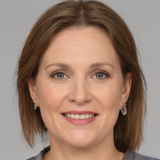 Joyful white adult female with medium  brown hair and grey eyes