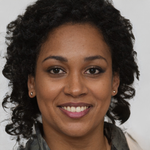 Joyful black adult female with long  brown hair and brown eyes