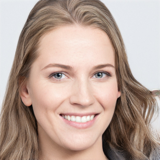 Joyful white young-adult female with long  brown hair and blue eyes