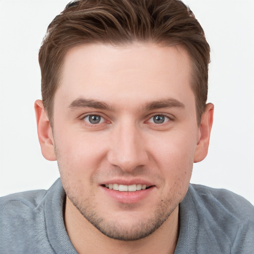 Joyful white young-adult male with short  brown hair and grey eyes