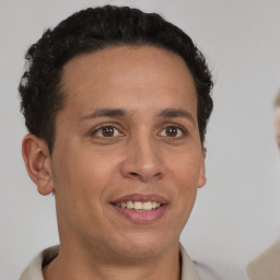 Joyful latino young-adult male with short  brown hair and brown eyes