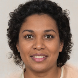 Joyful black adult female with long  brown hair and brown eyes