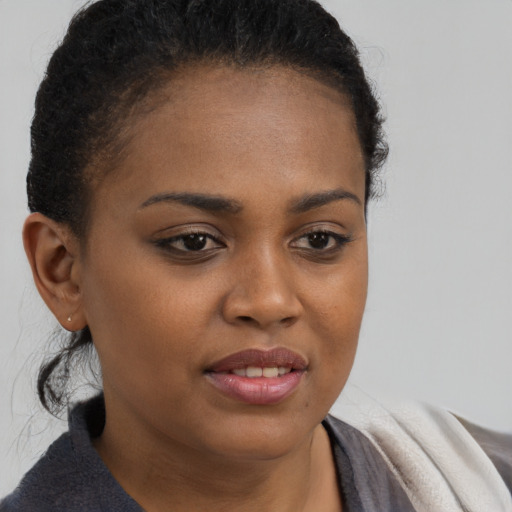 Joyful black young-adult female with short  brown hair and brown eyes