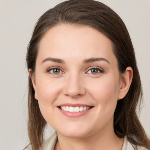 Joyful white young-adult female with medium  brown hair and grey eyes