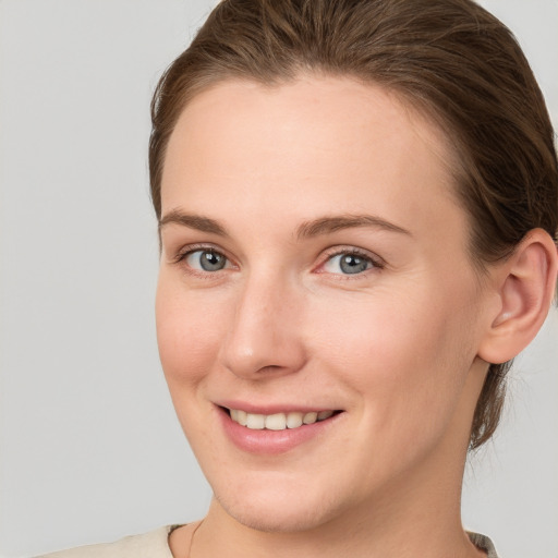 Joyful white young-adult female with short  brown hair and grey eyes