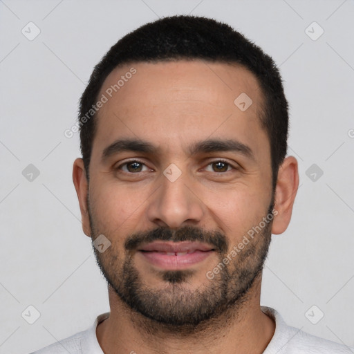 Joyful white young-adult male with short  black hair and brown eyes