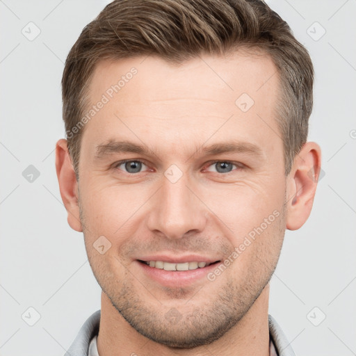 Joyful white young-adult male with short  brown hair and grey eyes