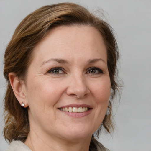 Joyful white adult female with medium  brown hair and blue eyes