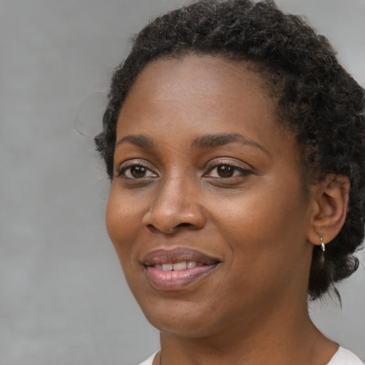 Joyful black young-adult female with medium  brown hair and brown eyes