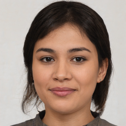 Joyful latino young-adult female with medium  brown hair and brown eyes