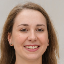 Joyful white young-adult female with long  brown hair and grey eyes