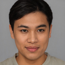 Joyful asian young-adult male with short  brown hair and brown eyes