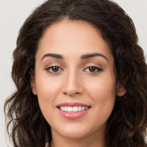 Joyful white young-adult female with long  brown hair and brown eyes