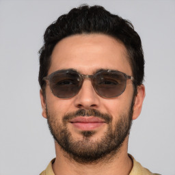 Joyful white young-adult male with short  black hair and brown eyes