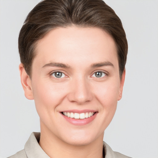 Joyful white young-adult female with short  brown hair and grey eyes