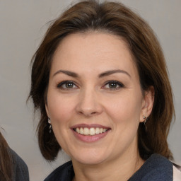 Joyful white adult female with medium  brown hair and brown eyes