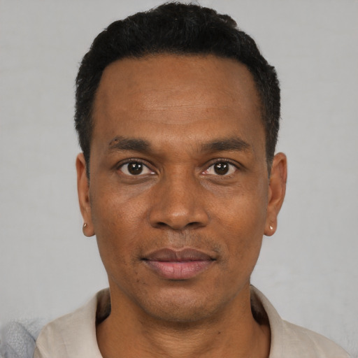 Joyful black young-adult male with short  black hair and brown eyes