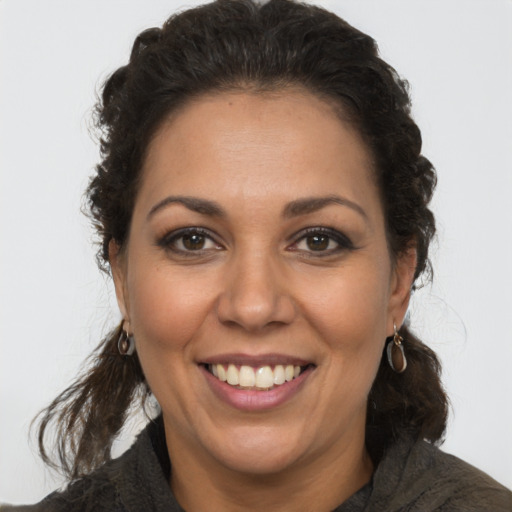 Joyful latino adult female with medium  brown hair and brown eyes