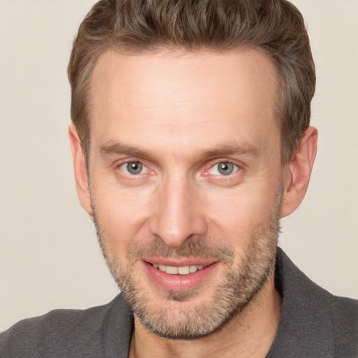 Joyful white adult male with short  brown hair and brown eyes