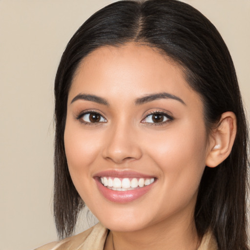 Joyful latino young-adult female with long  brown hair and brown eyes