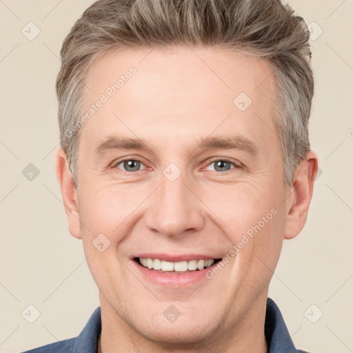 Joyful white adult male with short  brown hair and grey eyes