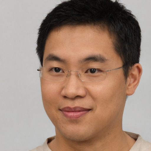 Joyful asian young-adult male with short  brown hair and brown eyes