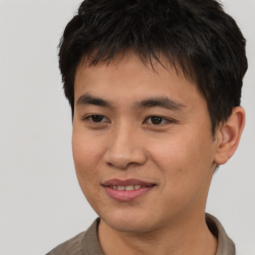 Joyful asian young-adult male with short  brown hair and brown eyes