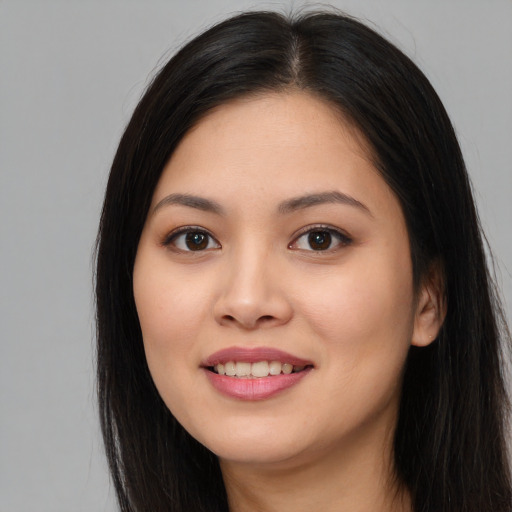 Joyful asian young-adult female with long  brown hair and brown eyes