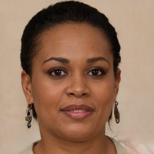 Joyful black young-adult female with short  brown hair and brown eyes