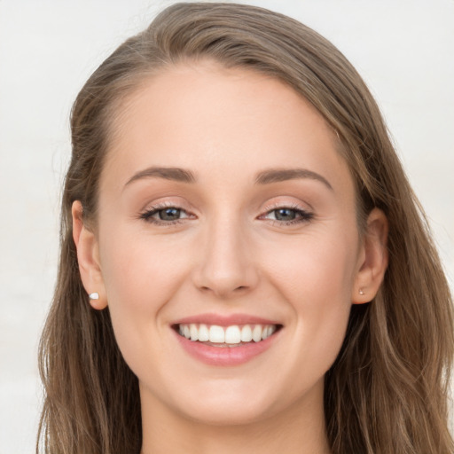 Joyful white young-adult female with long  brown hair and blue eyes