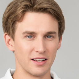 Joyful white young-adult male with short  brown hair and grey eyes