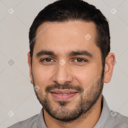 Joyful white young-adult male with short  black hair and brown eyes