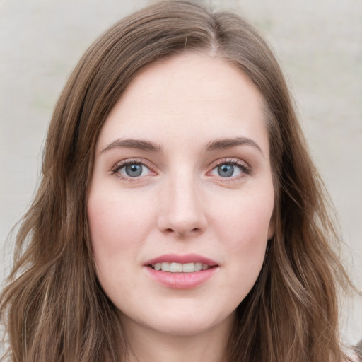 Joyful white young-adult female with long  brown hair and green eyes