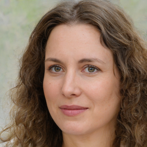 Joyful white adult female with long  brown hair and green eyes